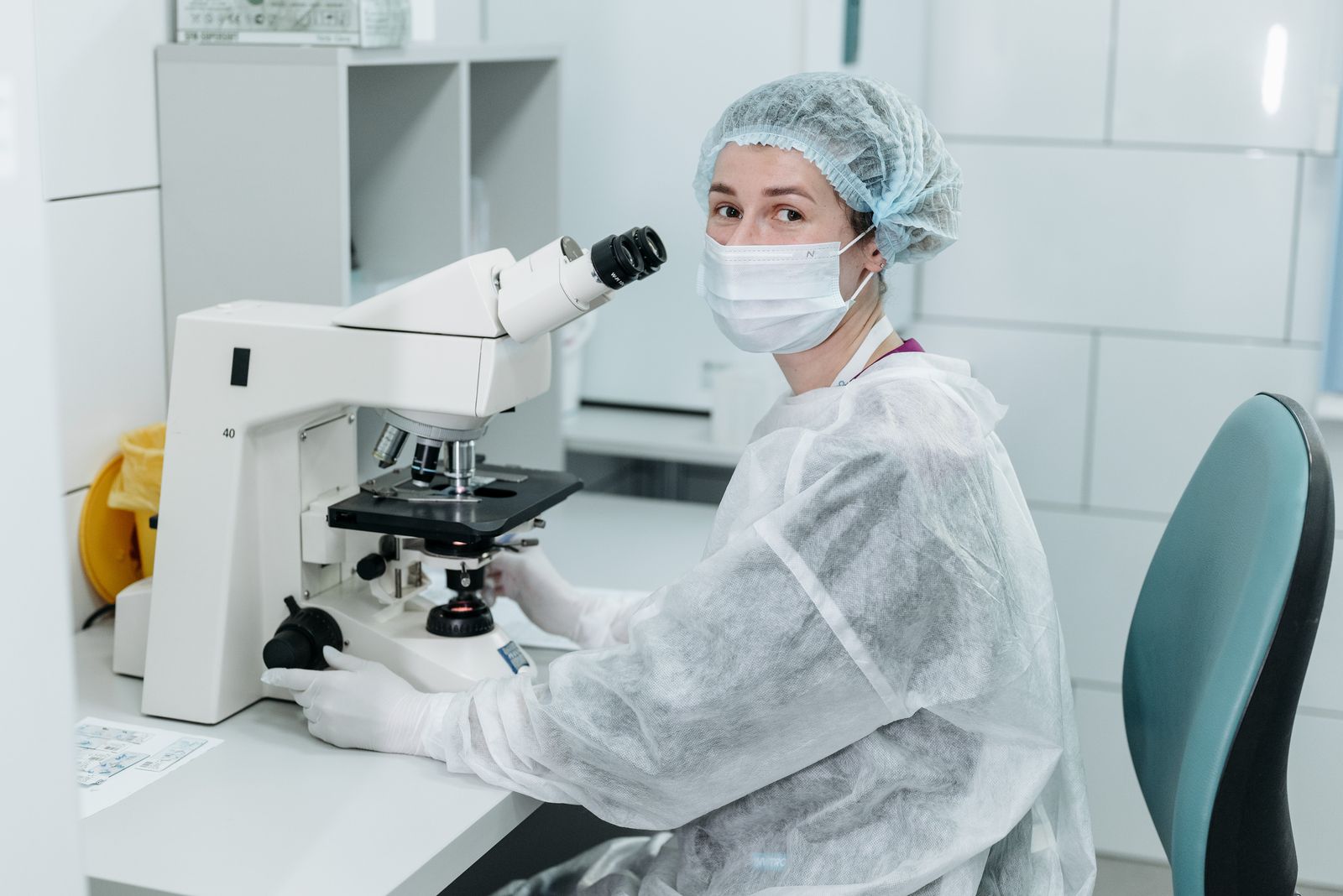 Biomedical scientist using a microscope in a research laboratory