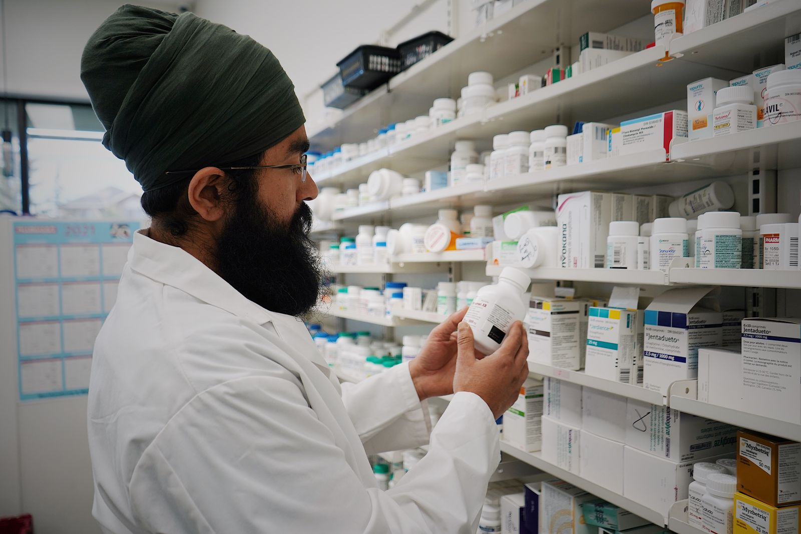Pharmacist working among medicine shelves in a modern pharmacy